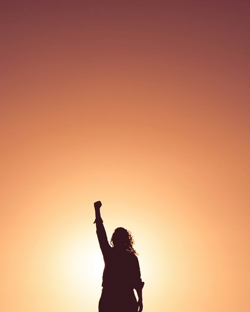 a person raising her fist in the air